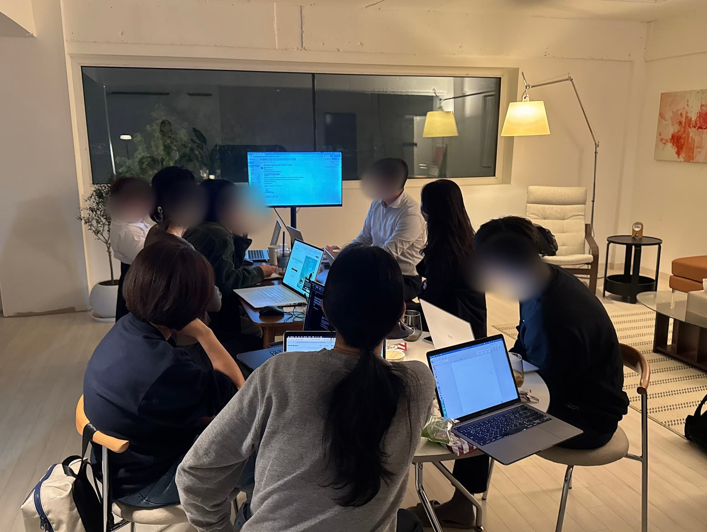첫 Arch Talk에서 참가자들이 테이블에 둘러앉아 노트북으로 AI 활용을 실습하는 모습